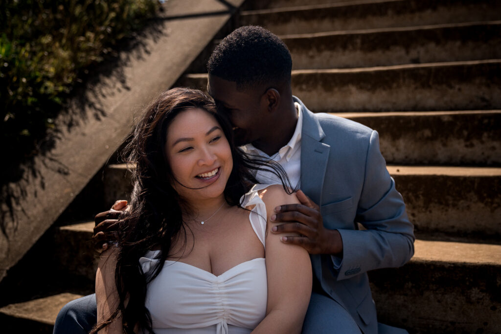 Couple sharing a romantic moment on stone steps during engagement photo session in San Francisco.