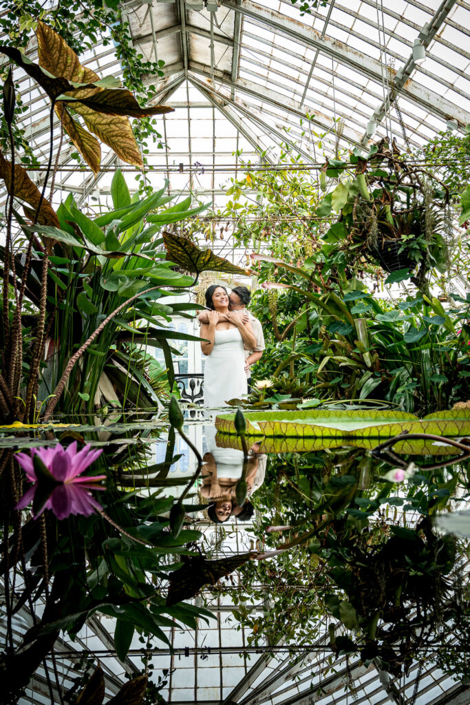 Couple embracing among greenhouse greenery at the Conservatory of Flowers in San Francisco