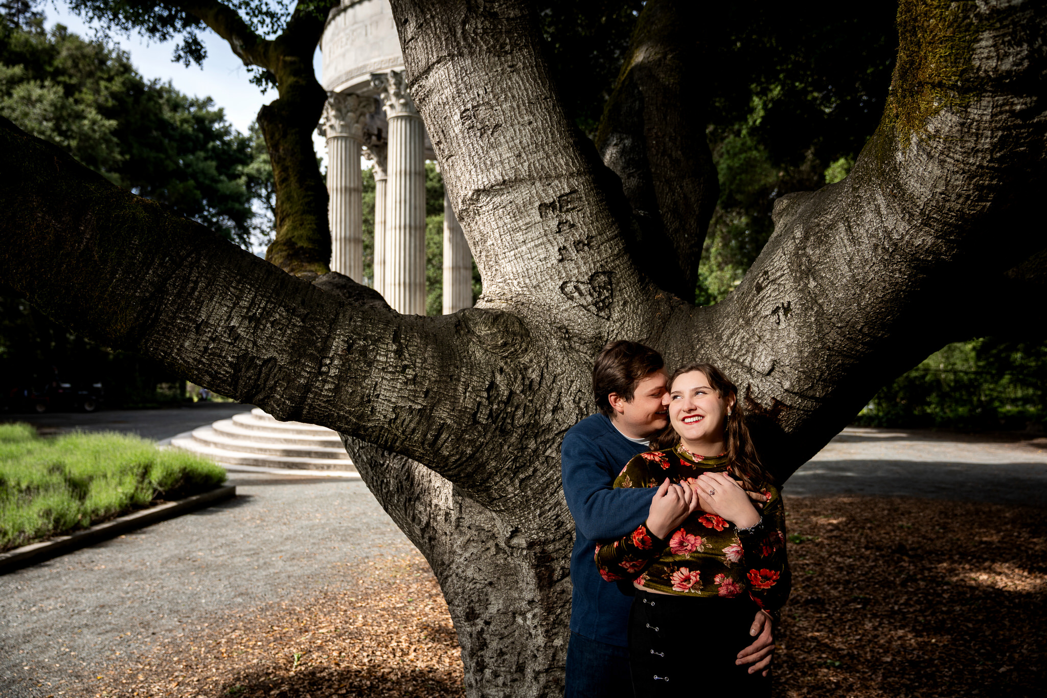 Couple laughing beneath a large oak tree near the Pulgas Water Temple