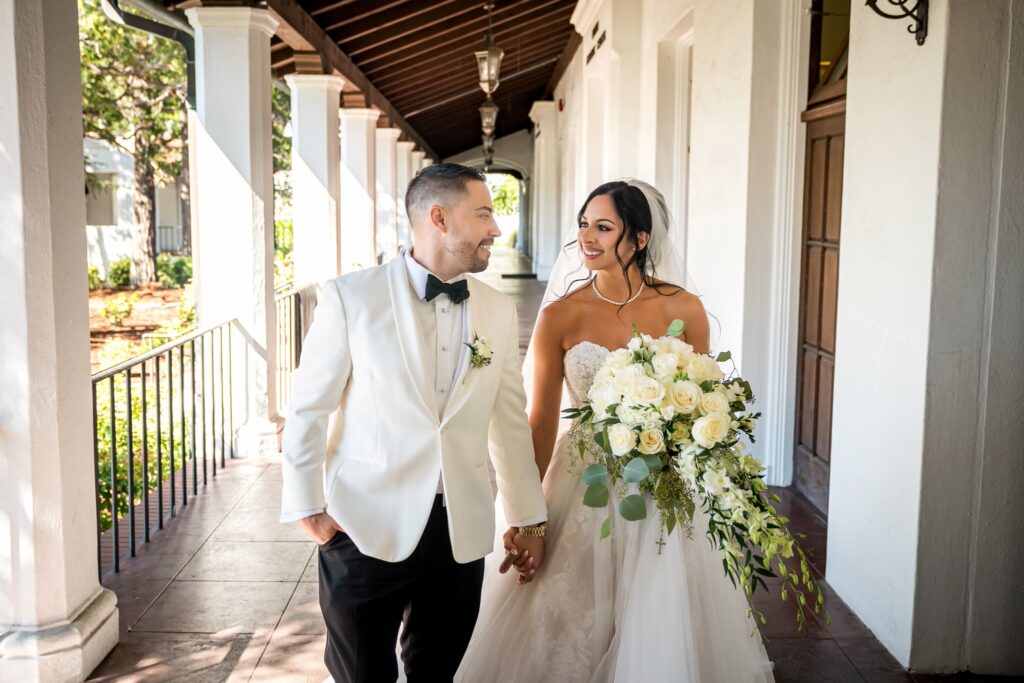 Bride and groom holding hands and smiling while walking together at Saint Mary’s College Chapel in Moraga California, photographed by a Northern California wedding photographer