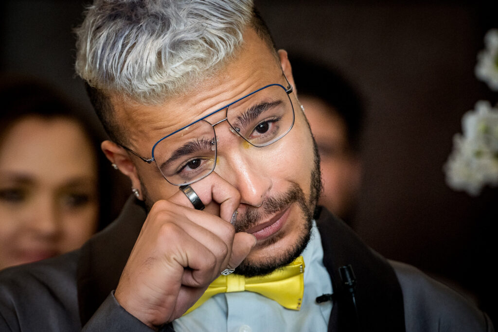 Groom crying during the wedding ceremony at Swedish American Hall in San Francisco, photographed by a Northern California wedding photographer