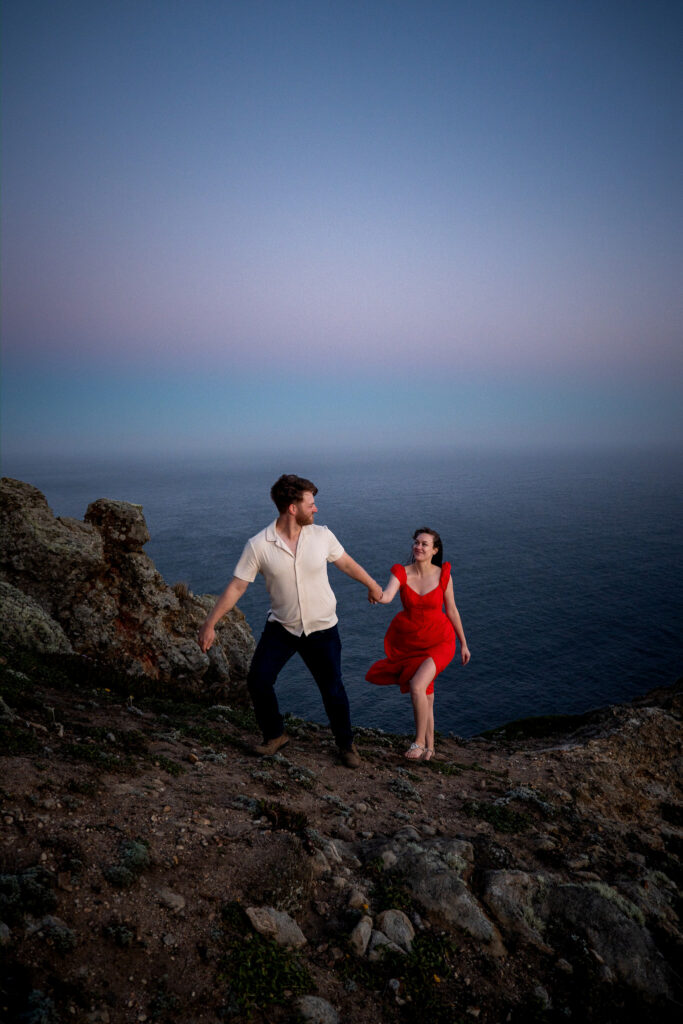 Woman in red dress against blue twilight ocean, complementary color contrast example at Point Reyes