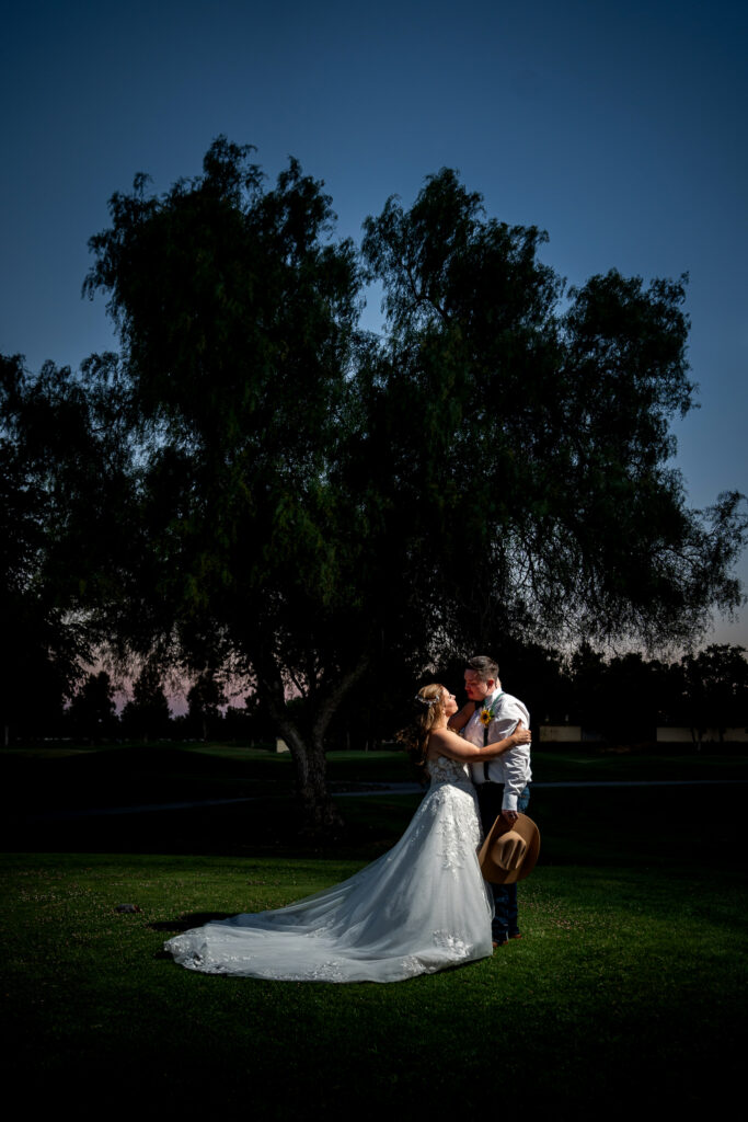 Bride and groom embracing on the golf course lawn at Bartley Cavanaugh at dusk
