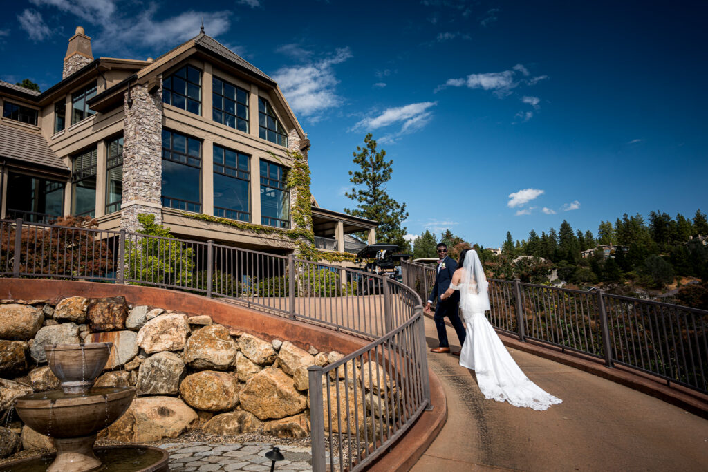 Bride and groom walking up a stone pathway toward the clubhouse at Winchester Country Club