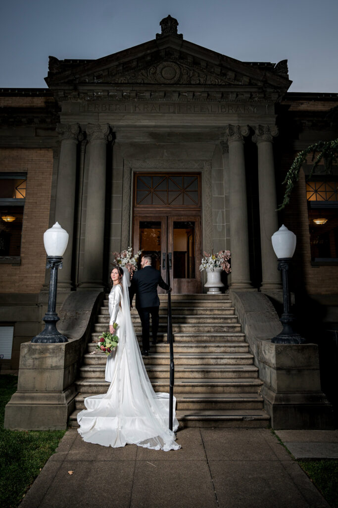 Bride and groom walking up the front steps of The Kraft in Red Bluff at dusk